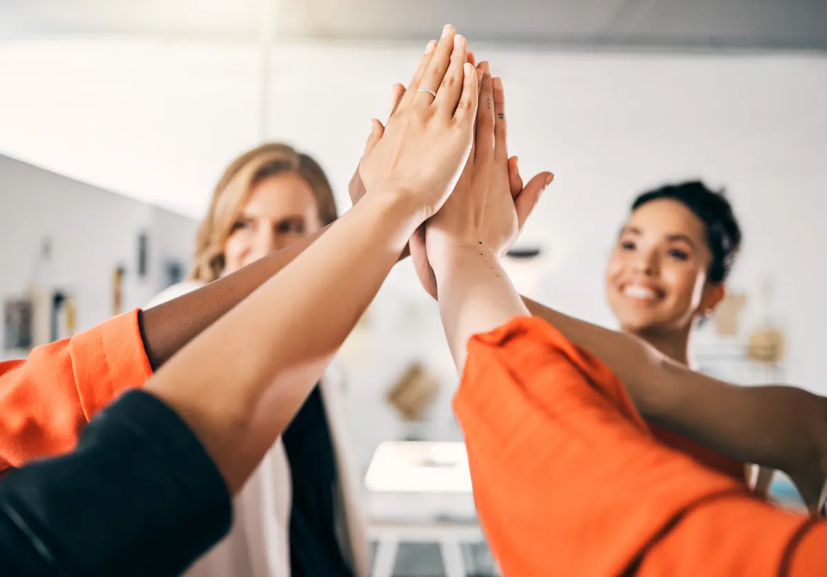 Fitness-Teamwork und High Five: Seniorinnen im Fitnessstudio feiern ihre Trainingsziele. Lachende Gesichter und eine Gruppe glücklicher Freundinnen, die sich für Erfolg und sportliche Erfolge die Hände reichen.